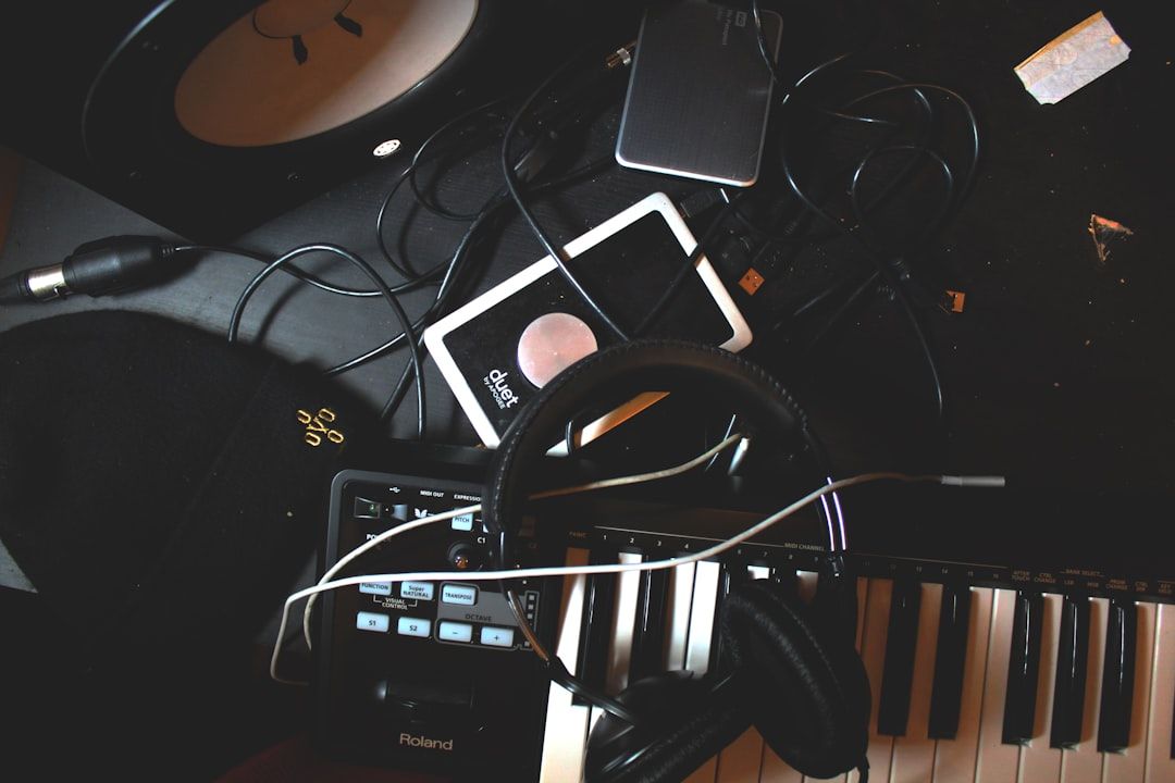 Överblick över musikstudio med hörlurar, keyboard, mixer och kablar.